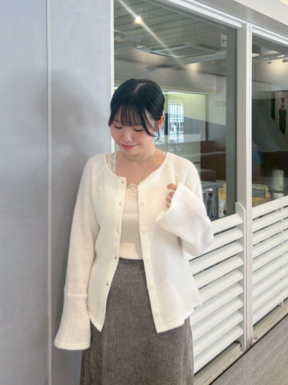 ホワイト系のキャミソール、ホワイト系のキャミソール、グレー系のスカートを着用したレディースの秋コーディネートの3枚目の写真