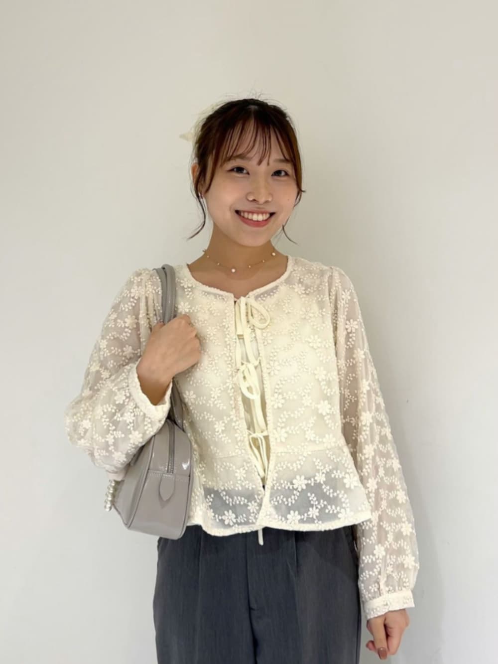 ホワイト系のシャツ/ブラウス、グレー系のパンツ、グレー系のショルダーバッグを着用したレディースの夏コーディネートの2枚目の写真