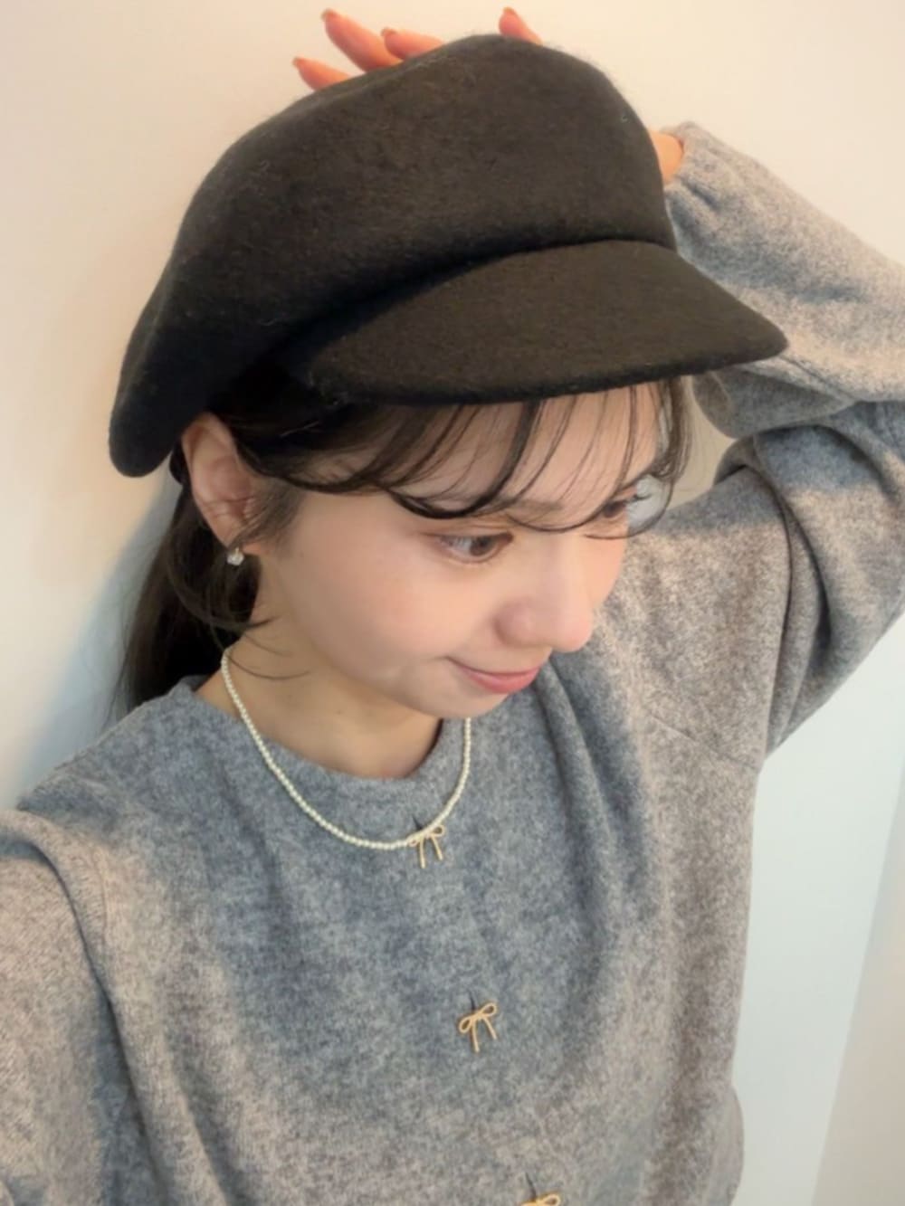 グレー系のカーディガン/ボレロ、ブラック系のキャスケットを着用したレディースの秋コーディネートの2枚目の写真