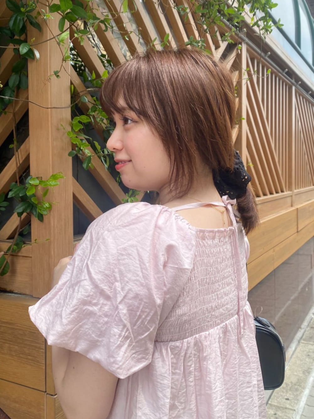 ブラック系のデニムスカート、ピンク系のシャツ/ブラウス、ベージュ系のスニーカーを着用したレディースの春コーディネートの2枚目の写真