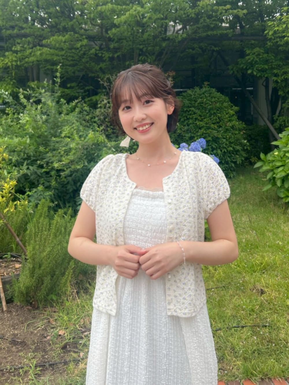 ブルー系のデニムパンツ、ブルー系のカーディガン/ボレロ、ホワイト系のワンピースを着用したレディースの夏コーディネートの2枚目の写真
