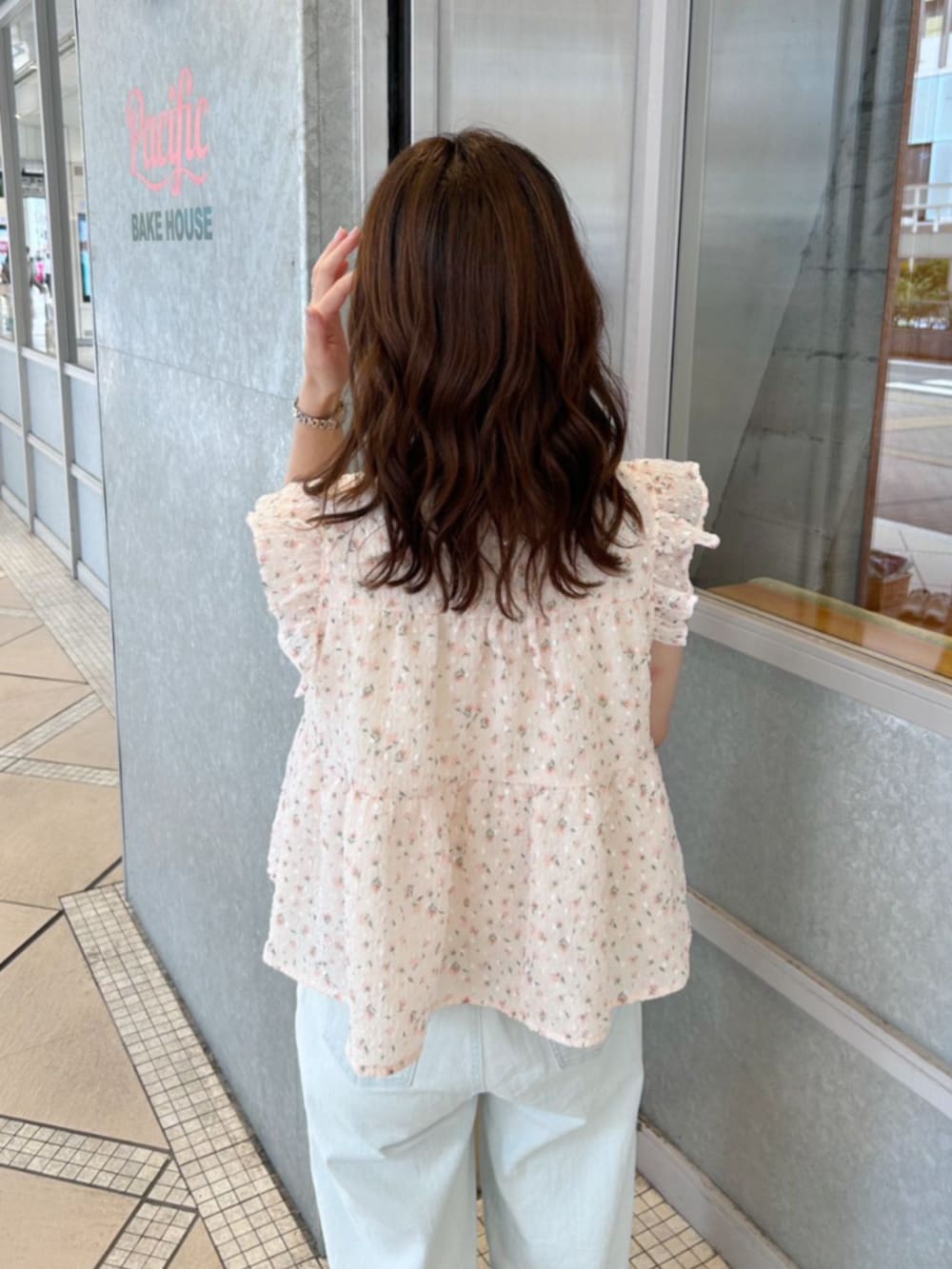 ホワイト系のショルダーバッグ、ブルー系のデニムパンツ、オレンジ系のシャツ/ブラウスを着用したレディースの夏コーディネートの3枚目の写真