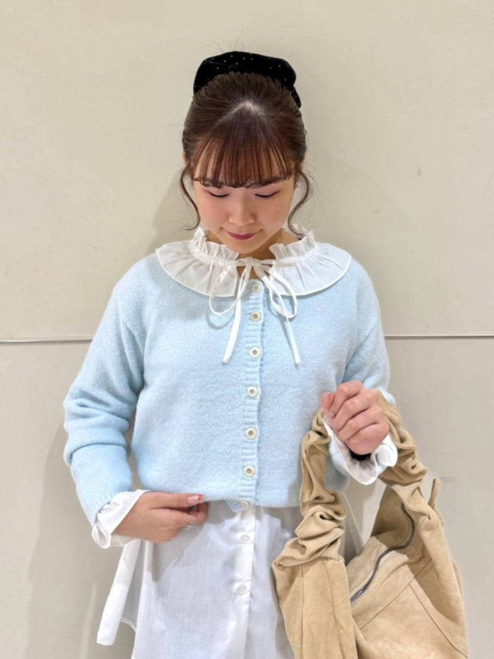 ホワイト系のシャツ/ブラウス、ベージュ系のショルダーバッグ、ブルー系のカーディガン/ボレロを着用したレディースの冬コーディネートの2枚目の写真