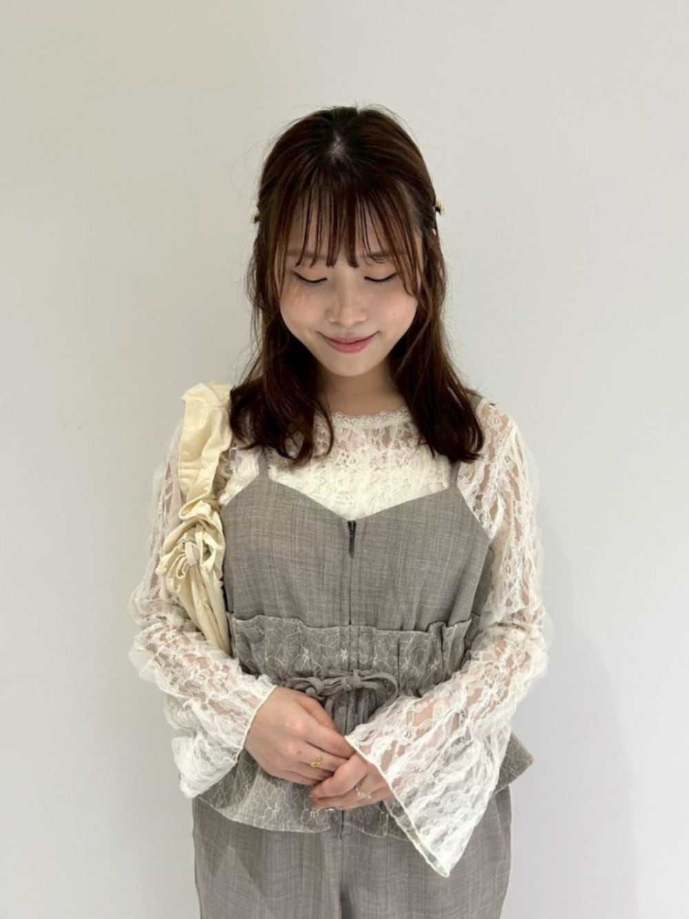 ホワイト系のショルダーバッグ、ホワイト系のTシャツ/カットソー、ブラウン系のつなぎ/オールインワンを着用したレディースの夏コーディネートの2枚目の写真