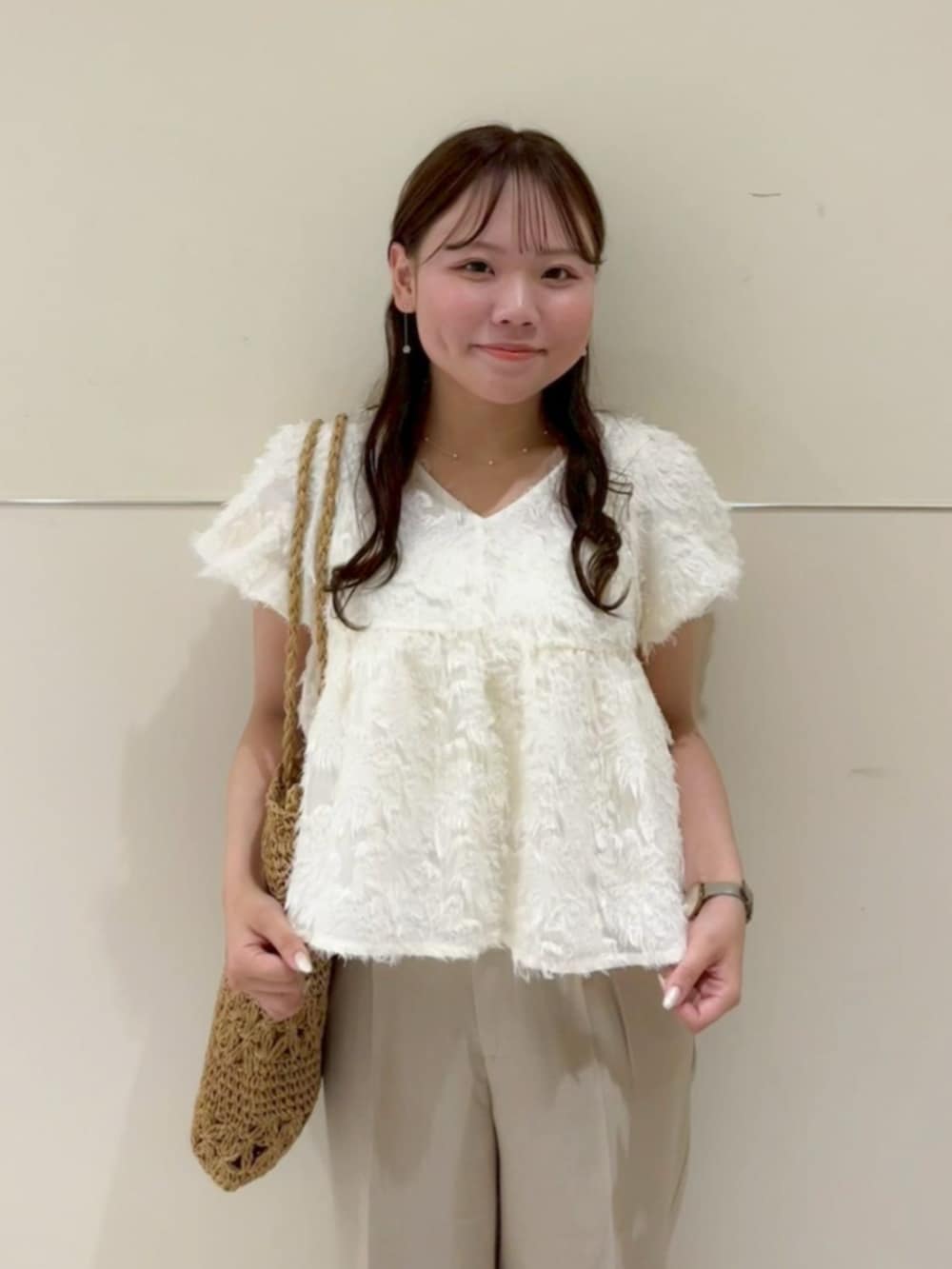 ベージュ系のかごバッグ、ベージュ系のその他パンツ、ホワイト系のシャツ/ブラウスを着用したレディースの夏コーディネートの2枚目の写真