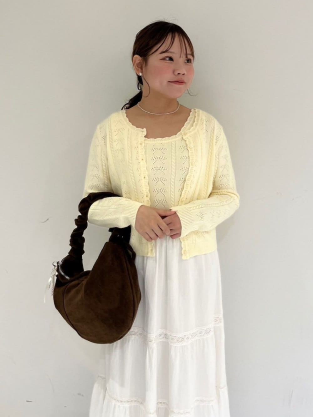 ホワイト系のスカート、ホワイト系のニット/セーター、ホワイト系のキーホルダーを着用したレディースの秋コーディネートの2枚目の写真