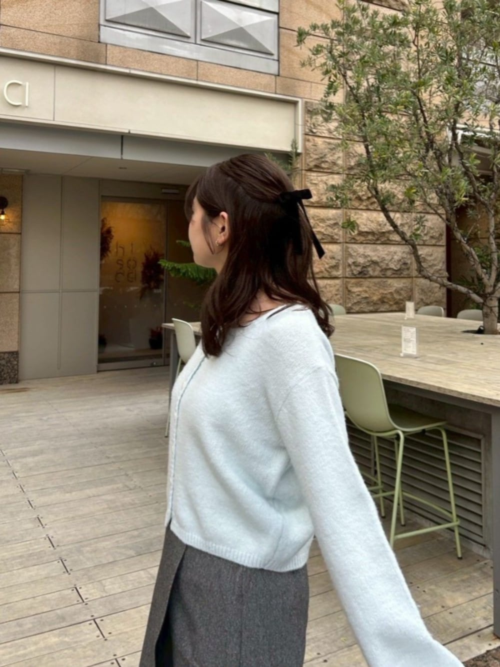 グレー系のスカート、ブルー系のカーディガン/ボレロ、ブラック系のブーツを着用したレディースの冬コーディネートの2枚目の写真