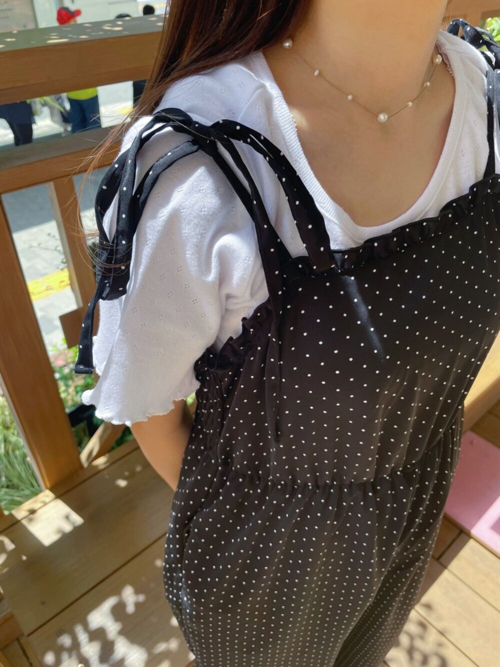 ホワイト系のショルダーバッグ、ブラック系のサロペット/オーバーオール、ホワイト系のTシャツ/カットソーを着用したレディースの春コーディネートの3枚目の写真