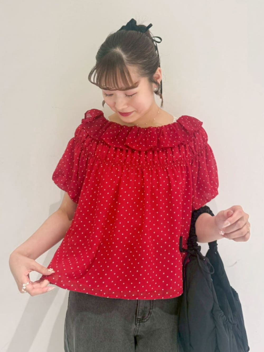 ブラック系のショルダーバッグ、ブラック系のデニムパンツ、レッド系のシャツ/ブラウスを着用したレディースの夏コーディネートの2枚目の写真