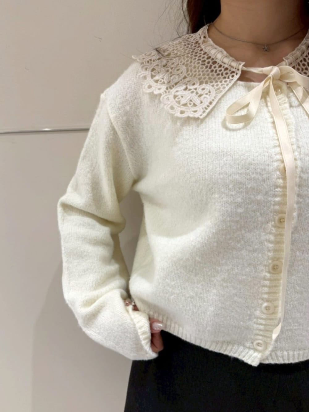 ブラック系のショルダーバッグ、イエロー系のカーディガン/ボレロ、グレー系のスカートを着用したレディースの冬コーディネートの3枚目の写真