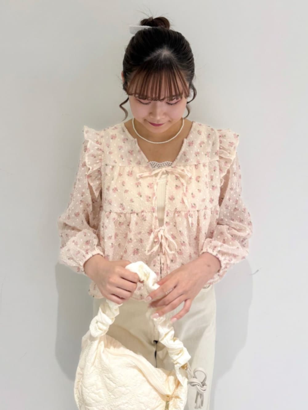 ホワイト系のショルダーバッグ、ピンク系のシャツ/ブラウス、ホワイト系のデニムパンツを着用したレディースの春コーディネートの2枚目の写真