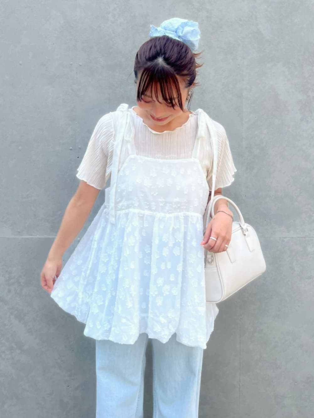 ホワイト系のTシャツ/カットソー、ブルー系のデニムパンツ、ホワイト系のキャミソールを着用したレディースの夏コーディネートの3枚目の写真