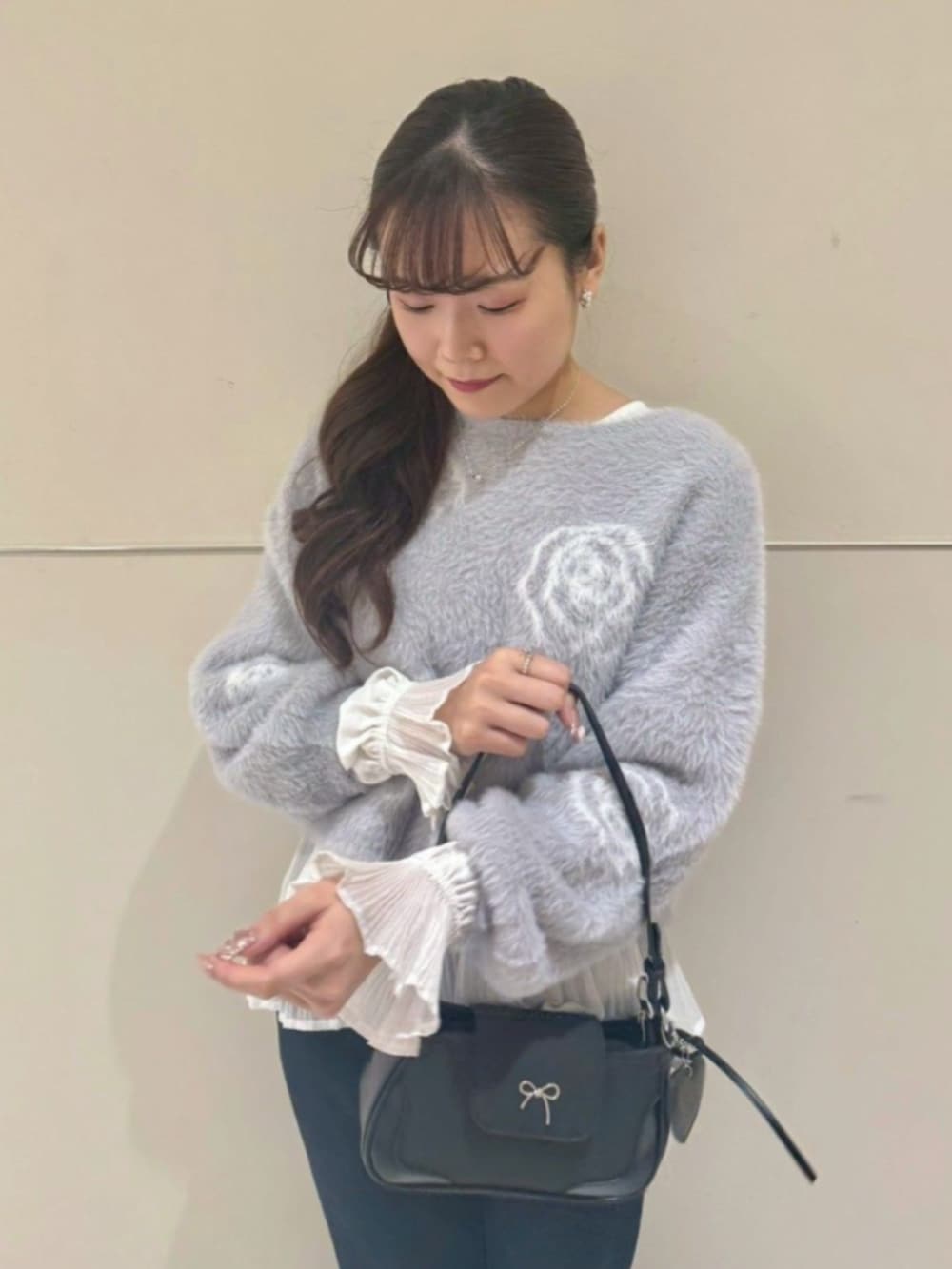 ホワイト系のシャツ/ブラウス、ブラック系のショルダーバッグ、グレー系のニット/セーターを着用したレディースの冬コーディネートの2枚目の写真