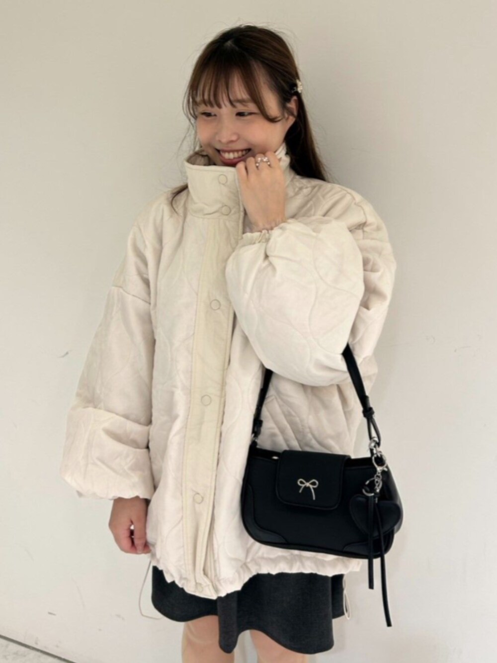 ホワイト系のナイロンジャケット、グレー系のスカート、ピンク系のニット/セーターを着用したレディースの秋コーディネートの5枚目の写真