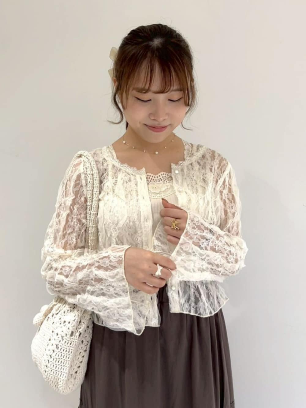 ホワイト系のキャミソール、ホワイト系のキャミソール、ホワイト系のショルダーバッグを着用したレディースの夏コーディネートの3枚目の写真