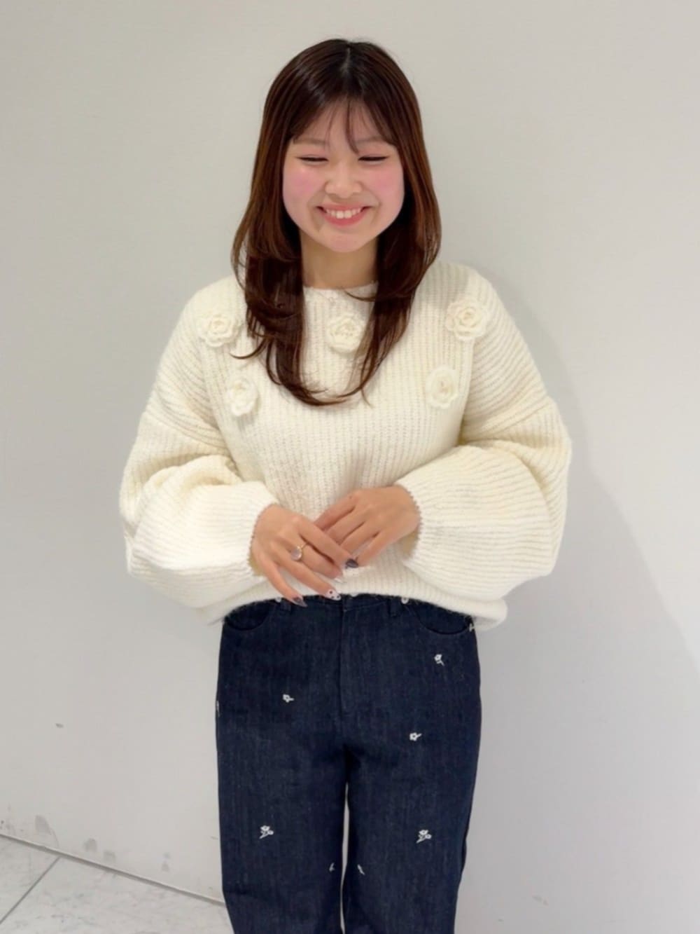 ブルー系のデニムパンツ、ホワイト系のニット/セーターを着用したレディースの冬コーディネートの2枚目の写真