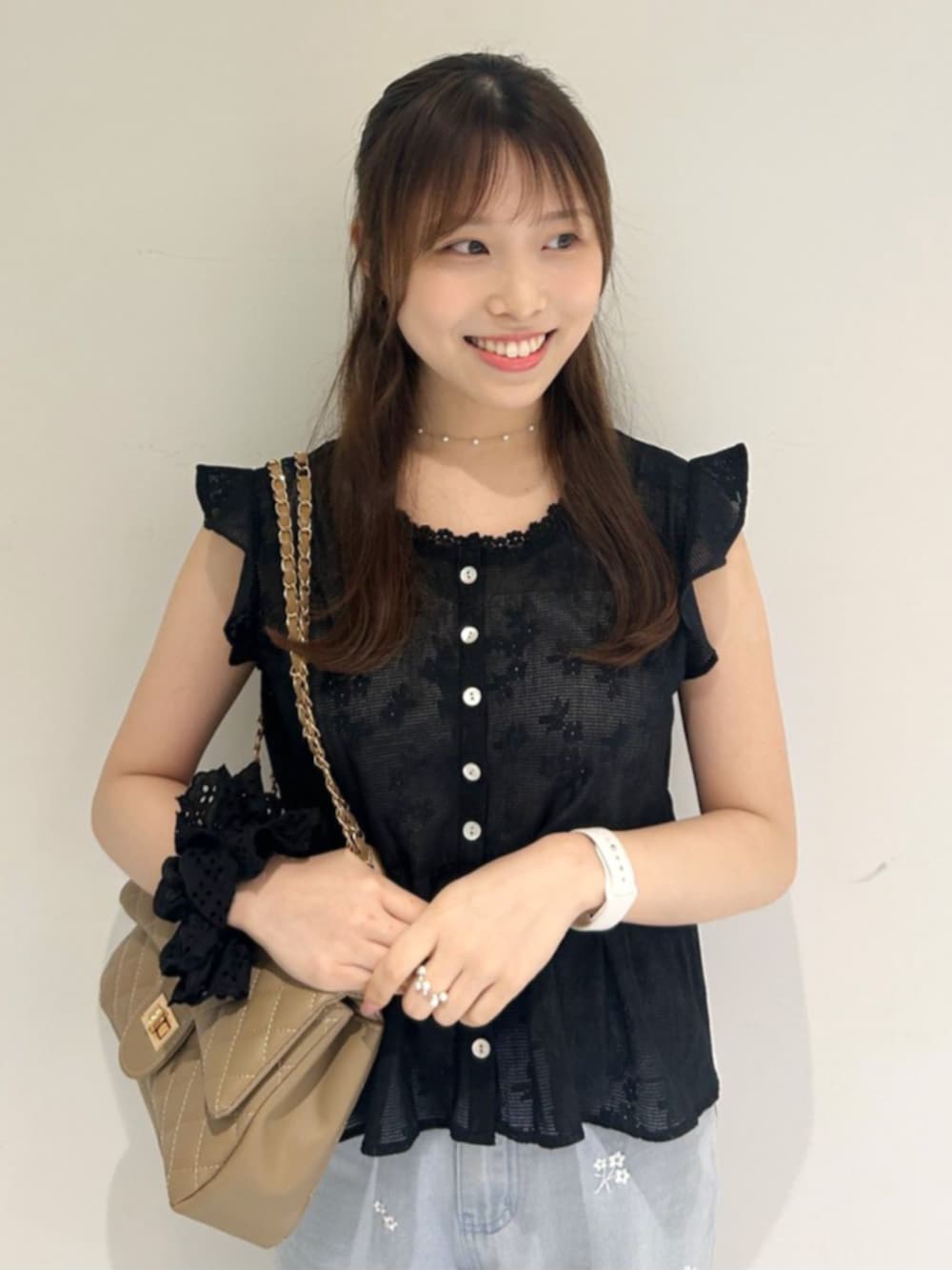 ベージュ系のショルダーバッグ、ブルー系のデニムパンツ、ブラック系のシャツ/ブラウスを着用したレディースの夏コーディネートの2枚目の写真