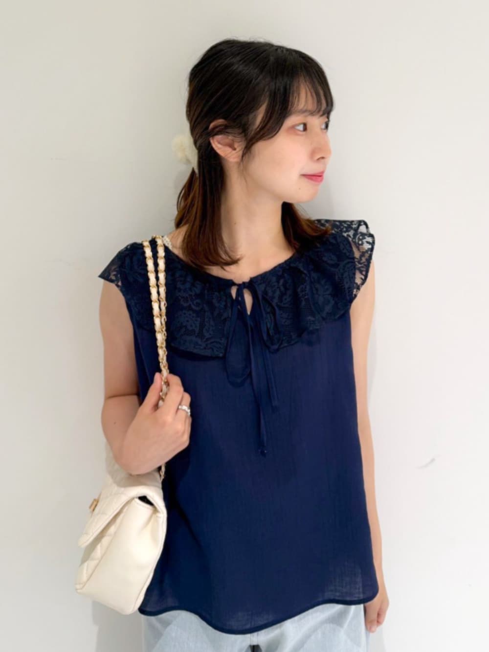 ブルー系のデニムパンツ、ホワイト系のショルダーバッグ、ブルー系のシャツ/ブラウスを着用したレディースの夏コーディネートの2枚目の写真