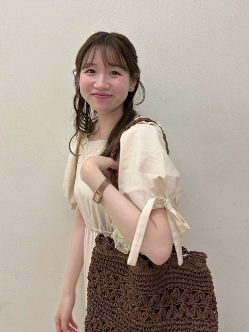 ホワイト系のワンピース、ブラウン系のトートバッグ、ゴールド系のバレエシューズを着用したレディースの夏コーディネートの2枚目の写真