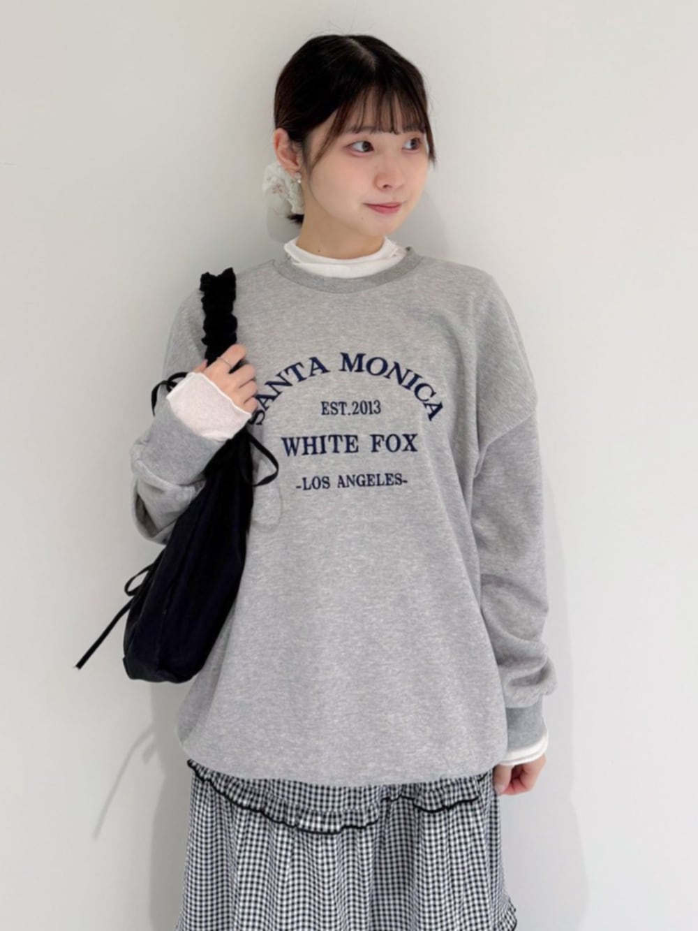 ブラック系のショルダーバッグ、グレー系のスウェット、ホワイト系のTシャツ/カットソーを着用したレディースの冬コーディネートの2枚目の写真
