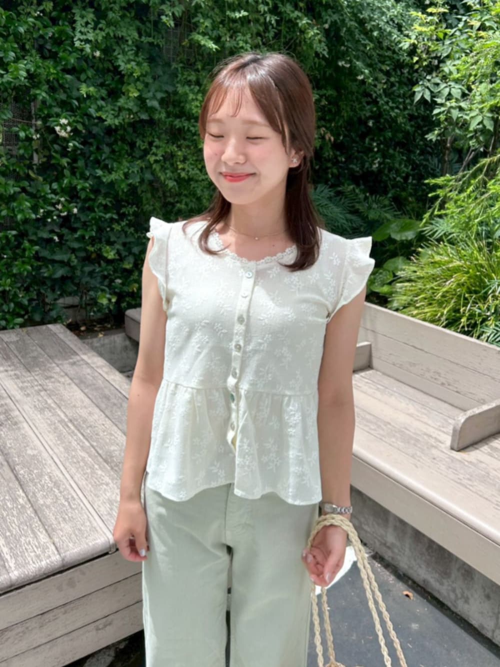 ホワイト系のかごバッグ、グリーン系のデニムパンツ、ホワイト系のシャツ/ブラウスを着用したレディースの夏コーディネートの2枚目の写真