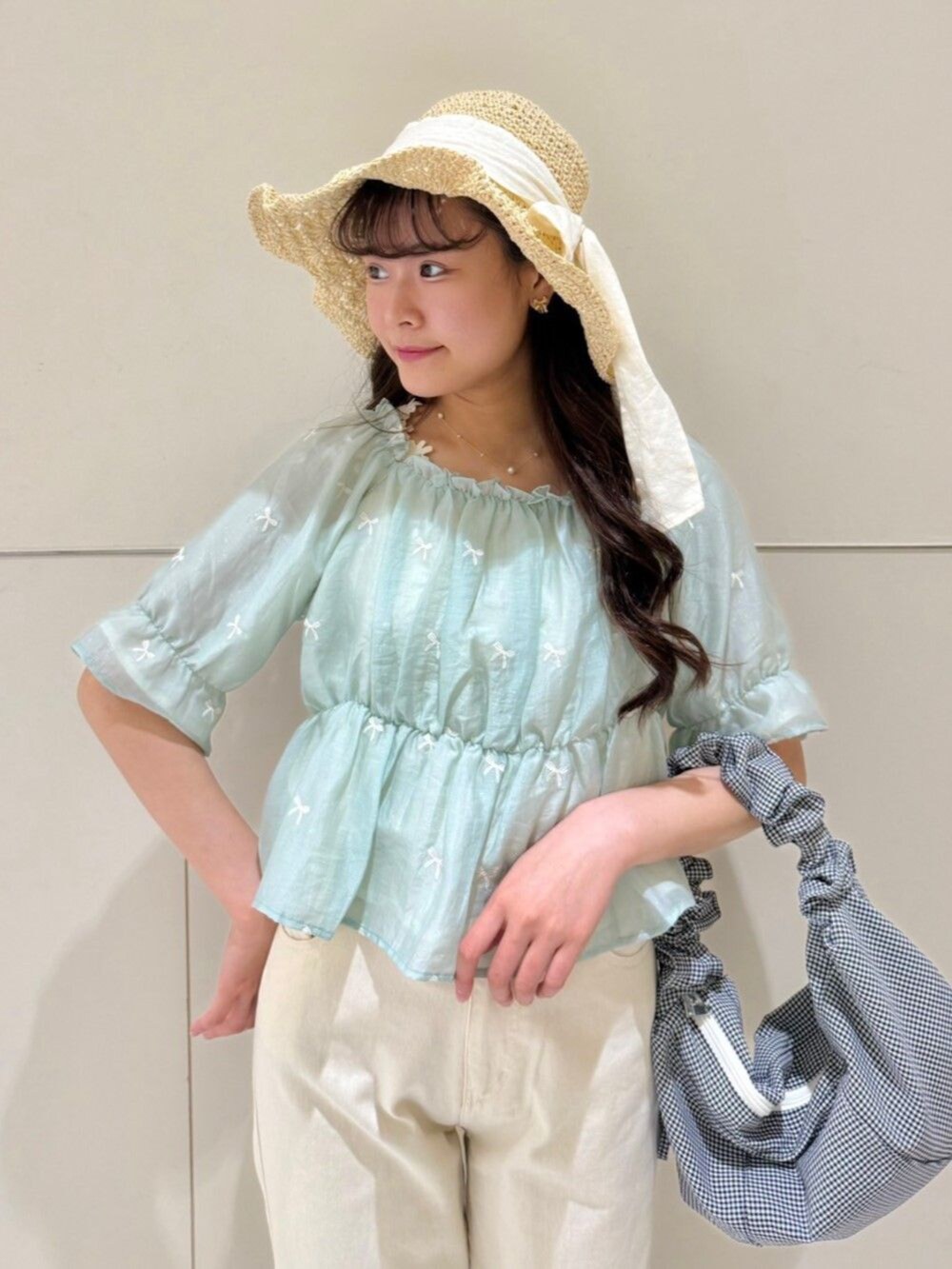 ホワイト系のデニムパンツ、ブラック系のショルダーバッグ、グリーン系のシャツ/ブラウスを着用したレディースの夏コーディネートの2枚目の写真