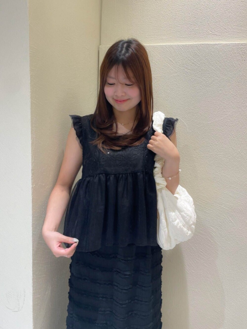 ホワイト系のショルダーバッグ、ブラック系のシャツ/ブラウス、ブラック系のスカートを着用したレディースの夏コーディネートの2枚目の写真