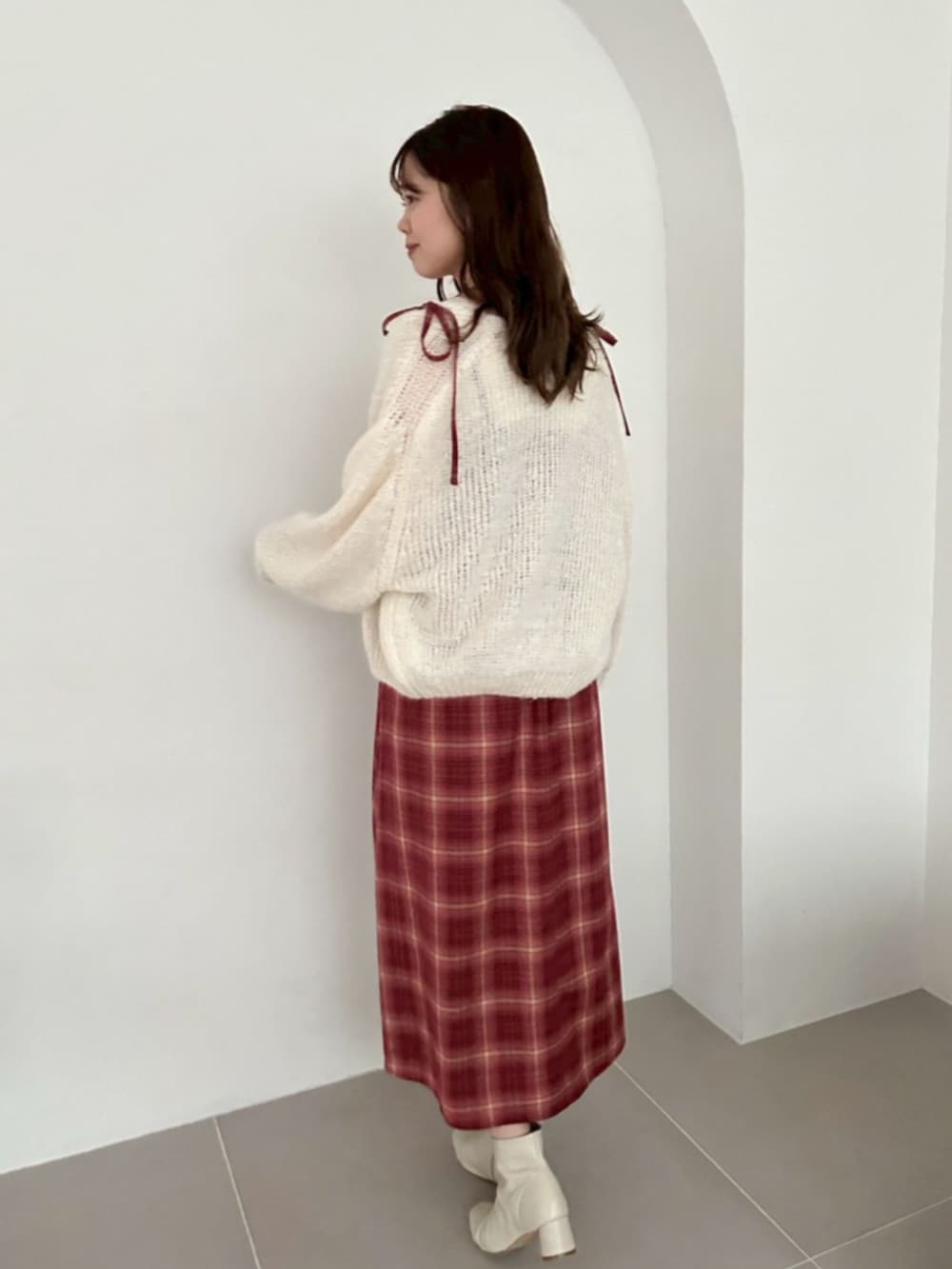 ホワイト系のカーディガン/ボレロ、レッド系のワンピース、ホワイト系のブーツを着用したレディースの秋コーディネートの2枚目の写真