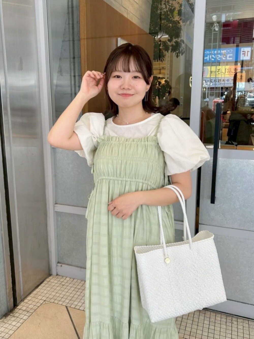 グリーン系のワンピース、ホワイト系のシャツ/ブラウス、ゴールド系のネックレスを着用したレディースの夏コーディネートの2枚目の写真