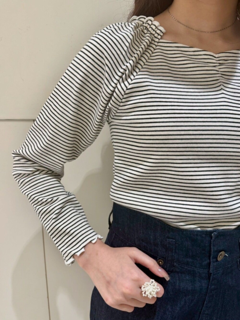 ブルー系のデニムパンツ、ホワイト系のキャミソール、ホワイト系のTシャツ/カットソーを着用したレディースの秋コーディネートの3枚目の写真