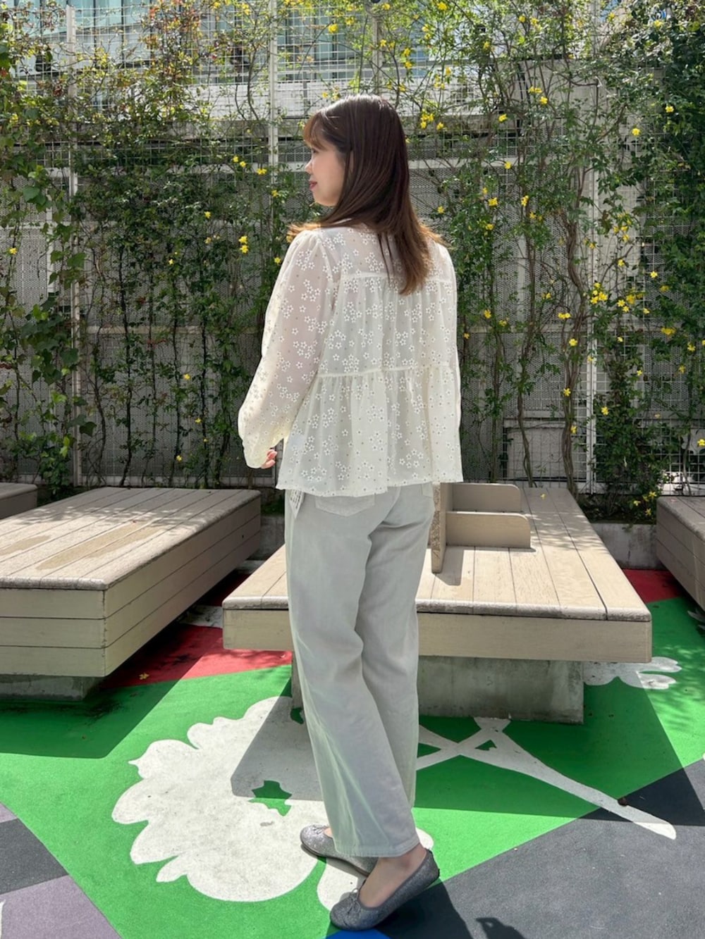 グリーン系のデニムパンツ、ホワイト系のシャツ/ブラウス、ゴールド系のキャミソールを着用したレディースの春コーディネートの2枚目の写真