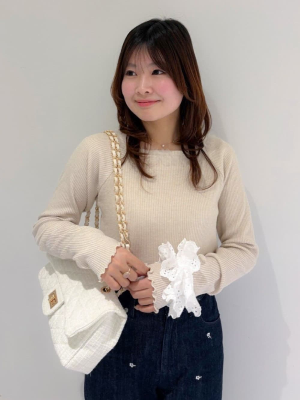 ホワイト系のショルダーバッグ、ブルー系のデニムパンツ、ホワイト系のTシャツ/カットソーを着用したレディースの冬コーディネートの2枚目の写真