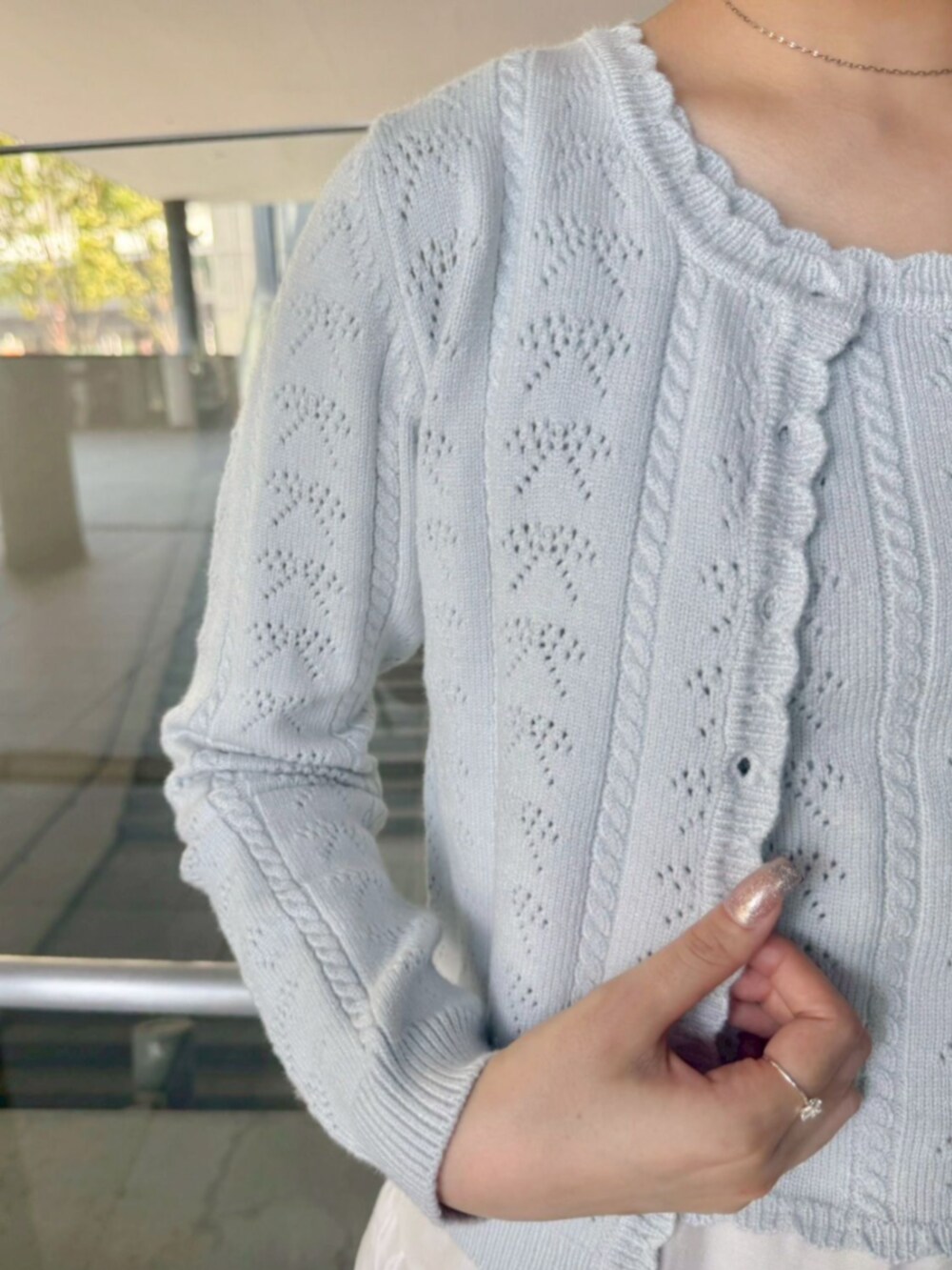 ブルー系のデニムパンツ、ブラック系のトートバッグ、ホワイト系のスカートを着用したレディースの秋コーディネートの2枚目の写真