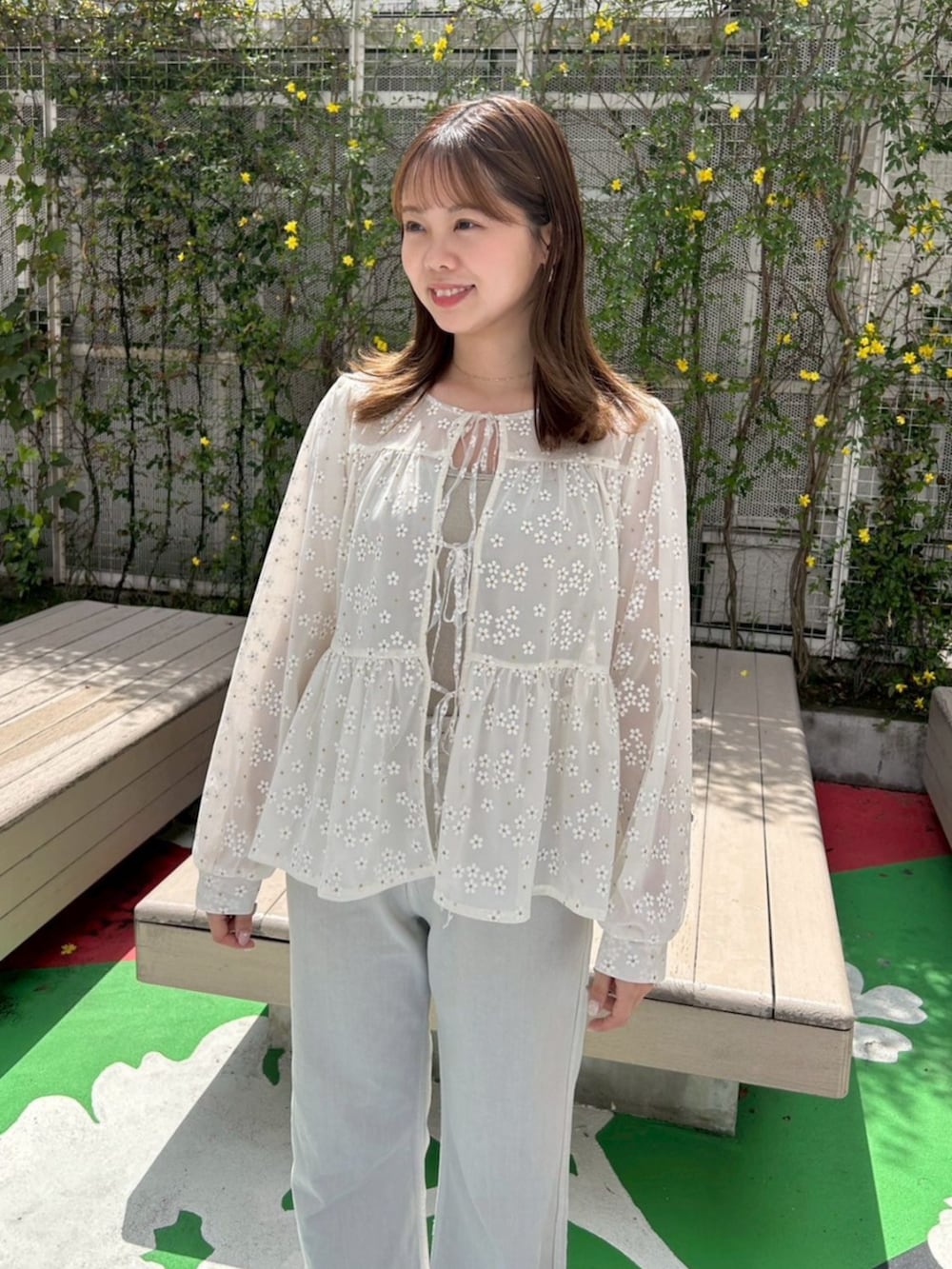 グリーン系のデニムパンツ、ホワイト系のシャツ/ブラウス、ゴールド系のキャミソールを着用したレディースの春コーディネートの3枚目の写真