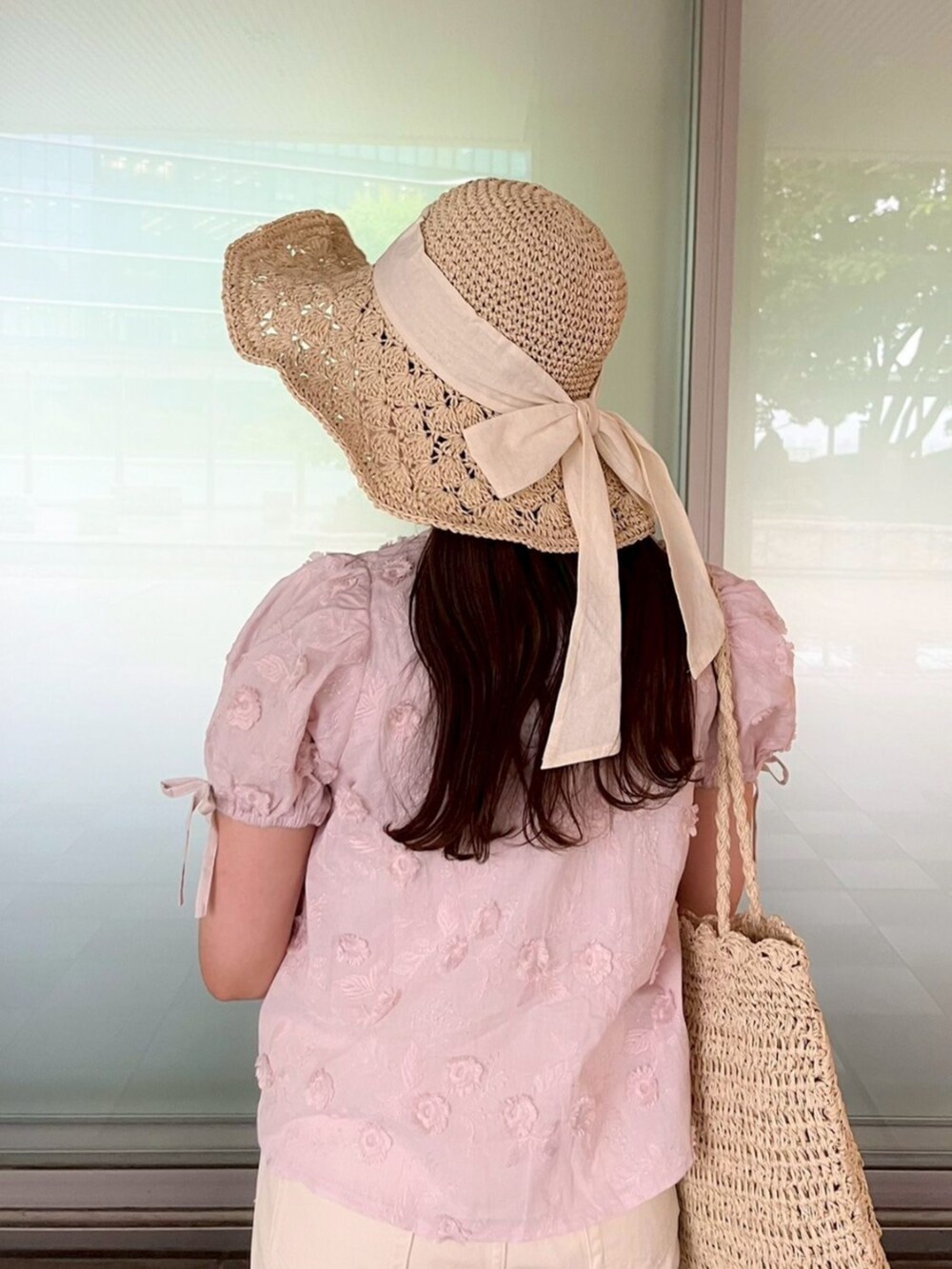 ホワイト系のキャミソール、ホワイト系のデニムパンツ、ベージュ系のかごバッグを着用したレディースの春コーディネートの5枚目の写真