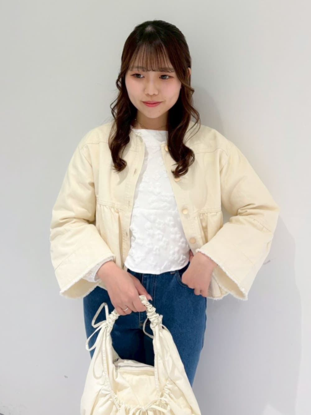 ホワイト系のショルダーバッグ、ホワイト系のシャツ/ブラウス、ホワイト系のデニムジャケットを着用したレディースの冬コーディネートの2枚目の写真