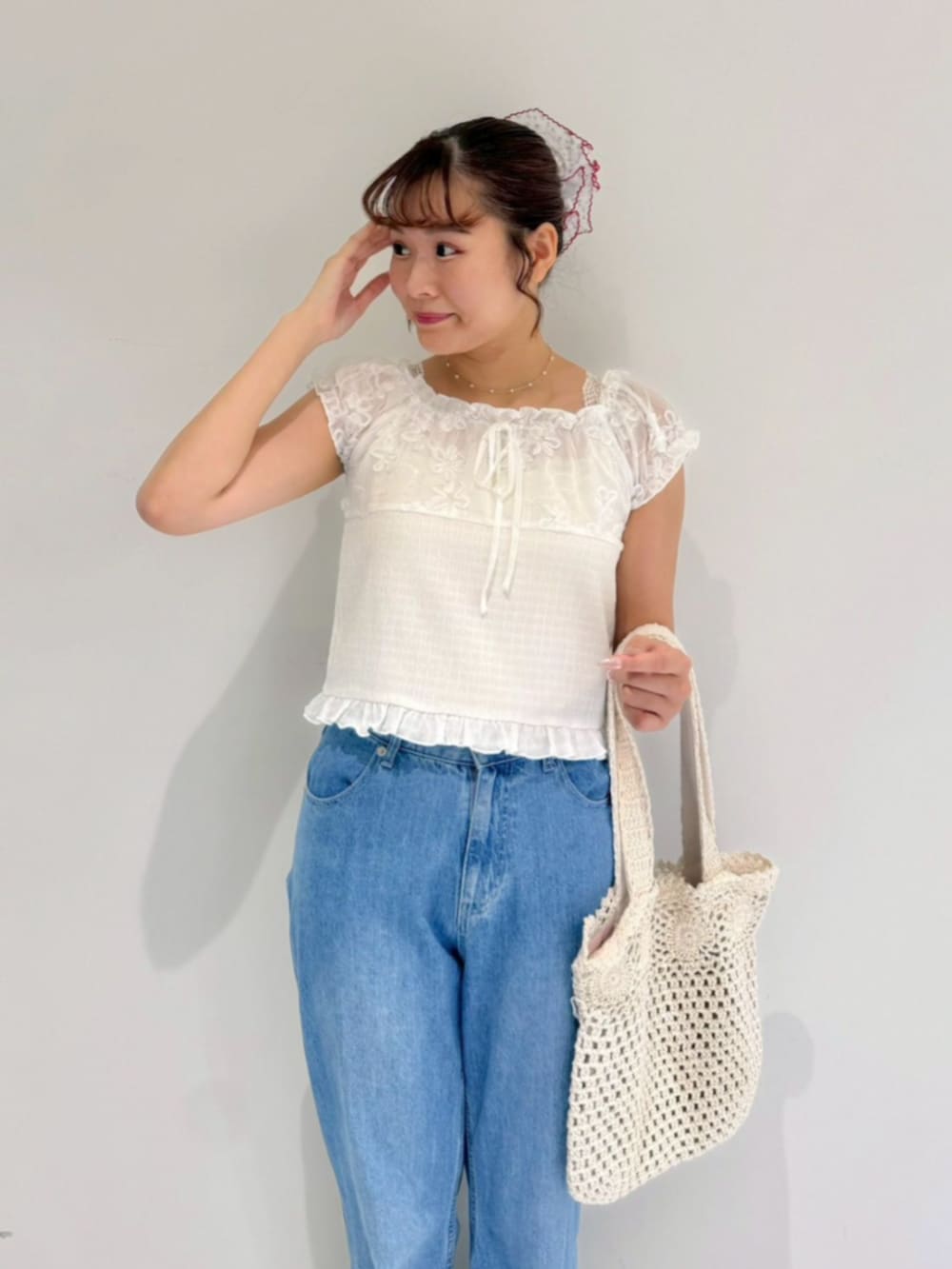 ブルー系のデニムパンツ、ホワイト系のトートバッグ、ホワイト系のシャツ/ブラウスを着用したレディースの夏コーディネートの2枚目の写真