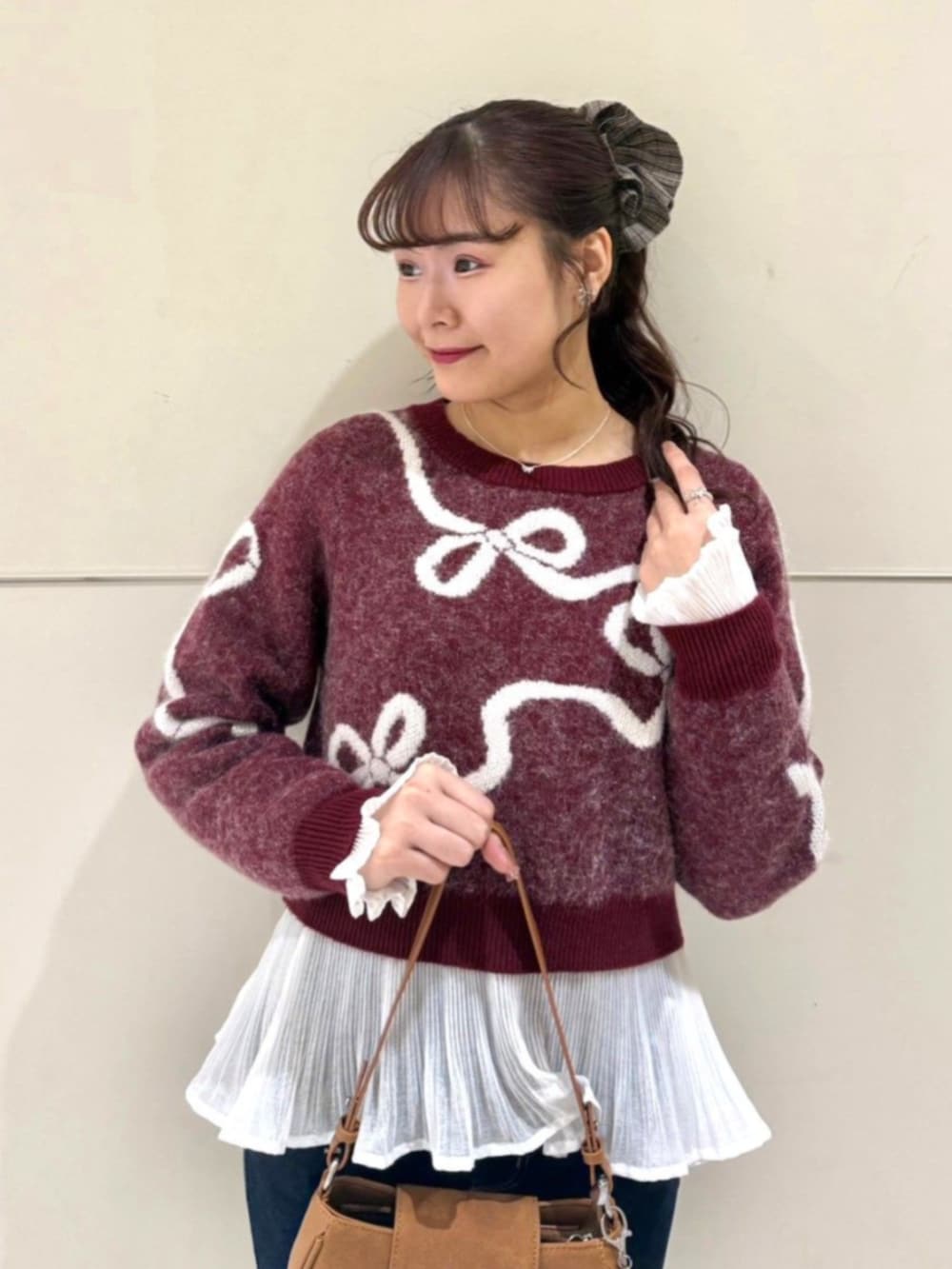 ホワイト系のシャツ/ブラウス、レッド系のニット/セーター、ブラウン系のショルダーバッグを着用したレディースの冬コーディネートの2枚目の写真