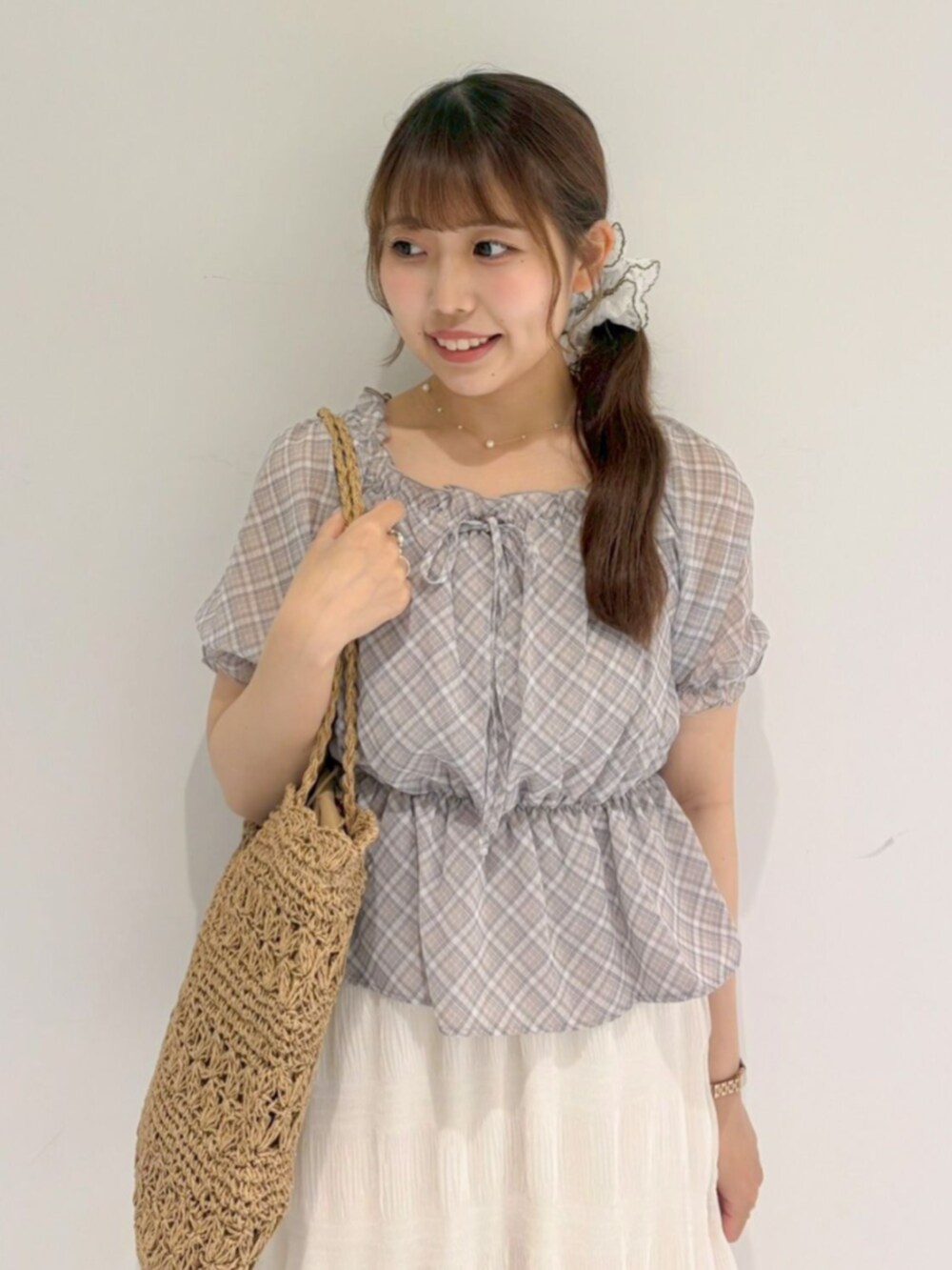 ベージュ系のかごバッグ、ホワイト系のスカート、ブラウン系のシャツ/ブラウスを着用したレディースの夏コーディネートの2枚目の写真