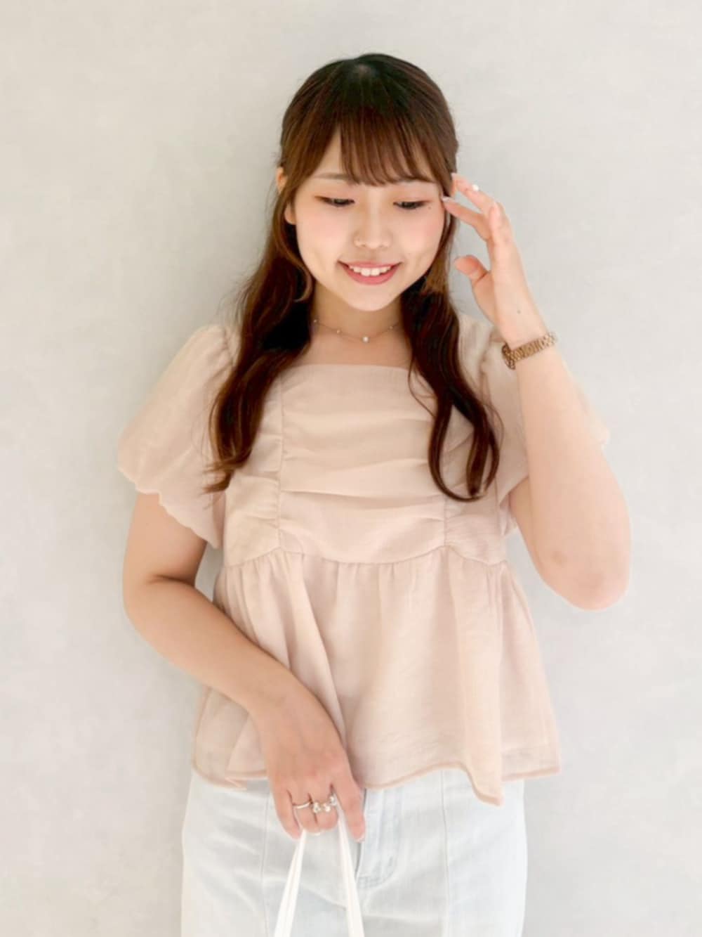 ピンク系のシャツ/ブラウス、ホワイト系のトートバッグ、ブルー系のデニムパンツを着用したレディースの春コーディネートの2枚目の写真