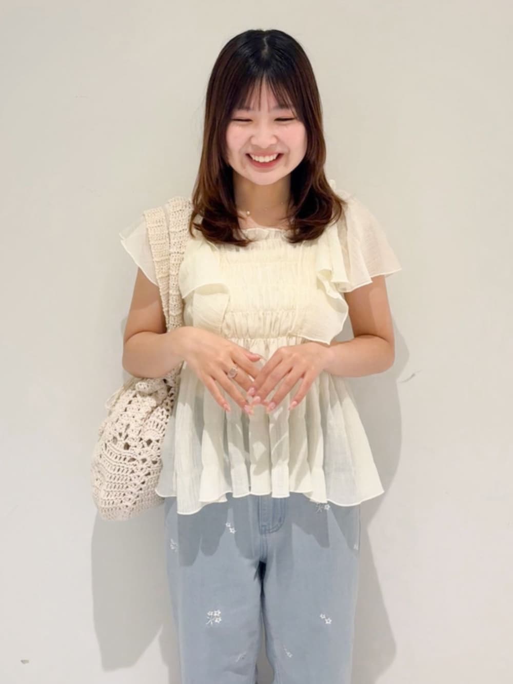 ホワイト系のシャツ/ブラウス、ホワイト系のショルダーバッグ、ブルー系のデニムパンツを着用したレディースの夏コーディネートの2枚目の写真