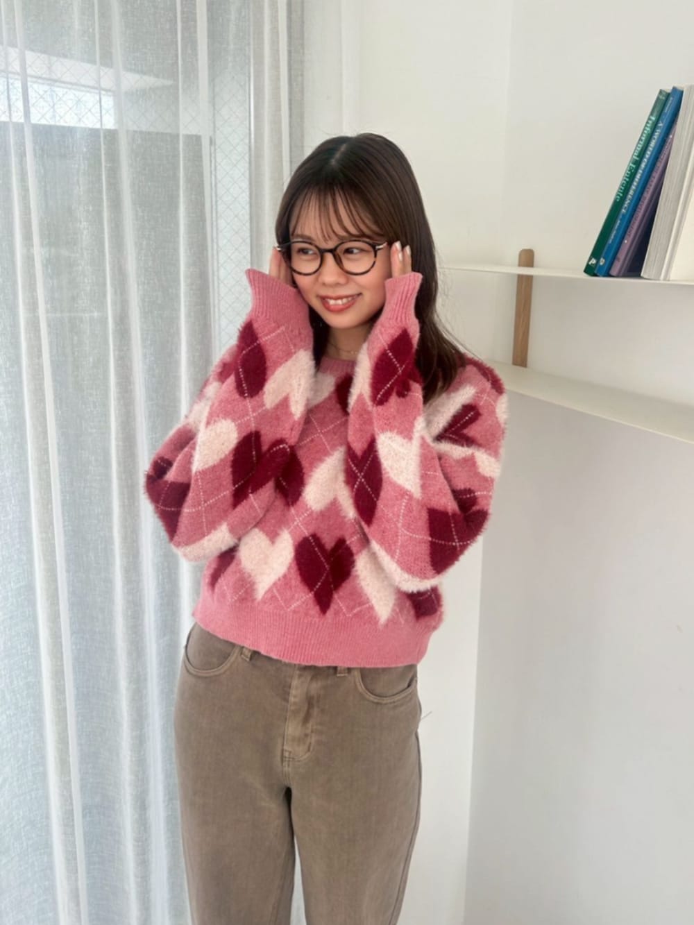 ブラウン系のデニムパンツ、レッド系のニット/セーターを着用したレディースの秋コーディネートの2枚目の写真