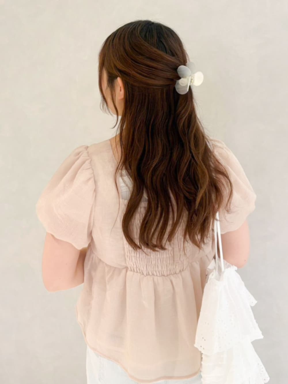 ピンク系のシャツ/ブラウス、ホワイト系のトートバッグ、ブルー系のデニムパンツを着用したレディースの春コーディネートの3枚目の写真
