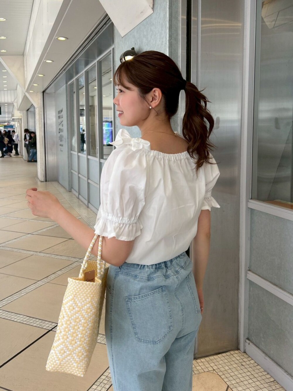 ブルー系のデニムパンツ、ホワイト系のシャツ/ブラウス、ゴールド系のピアス（片耳用）を着用したレディースの春コーディネートの4枚目の写真