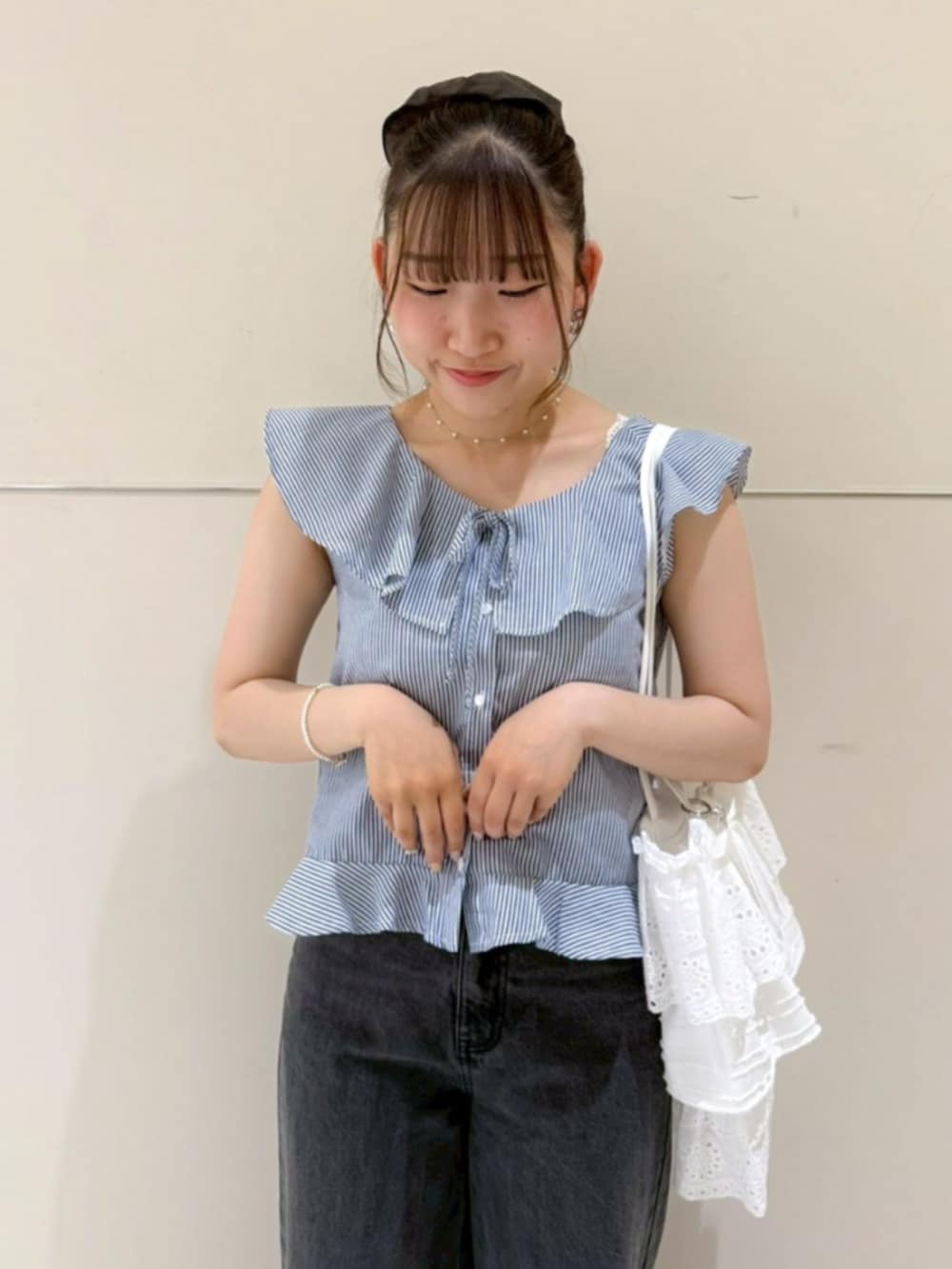 ブラック系のデニムパンツ、ホワイト系のトートバッグ、ブルー系のシャツ/ブラウスを着用したレディースの夏コーディネートの2枚目の写真