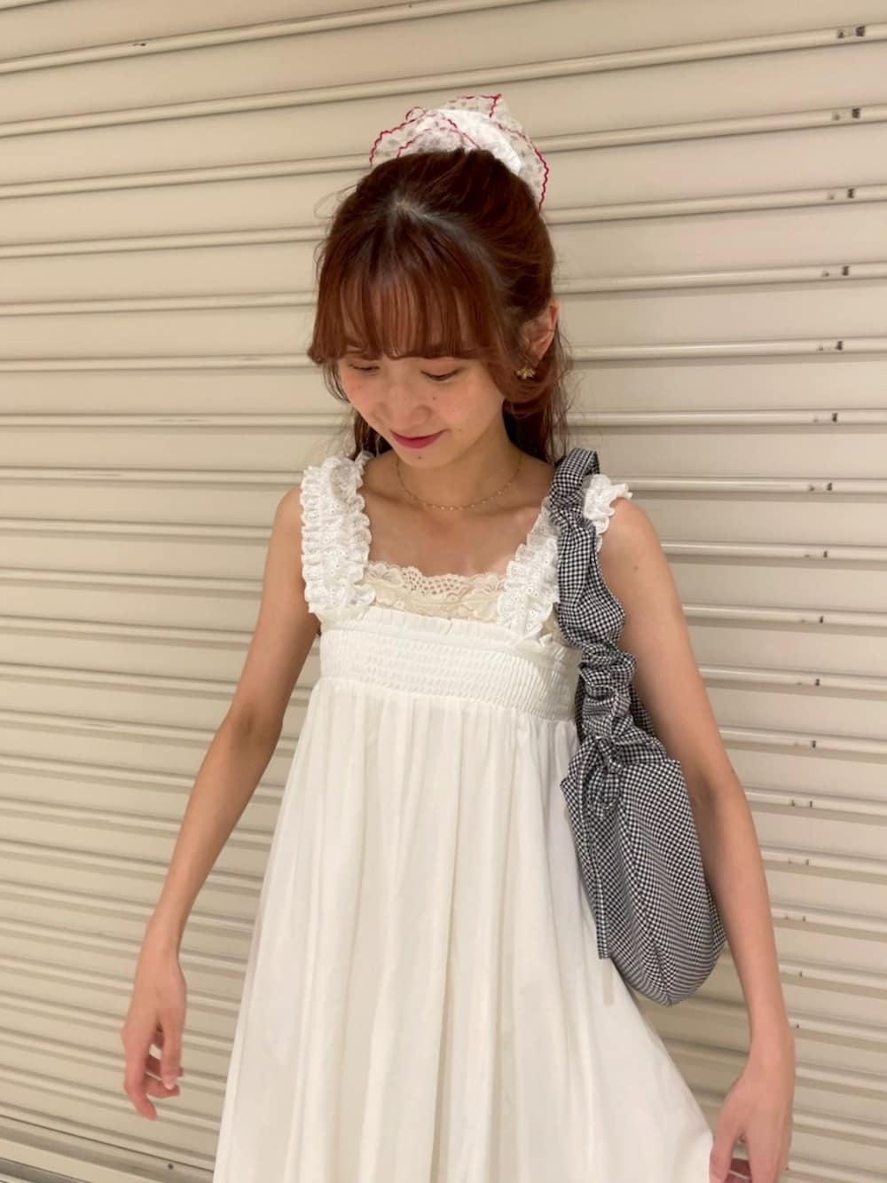 ホワイト系のキャミソール、ブラック系のショルダーバッグ、ホワイト系のキャミソールを着用したレディースの夏コーディネートの2枚目の写真