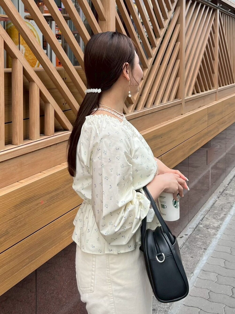 ホワイト系のデニムパンツ、ブラック系のハンドバッグ、ホワイト系のシャツ/ブラウスを着用したレディースの春コーディネートの4枚目の写真