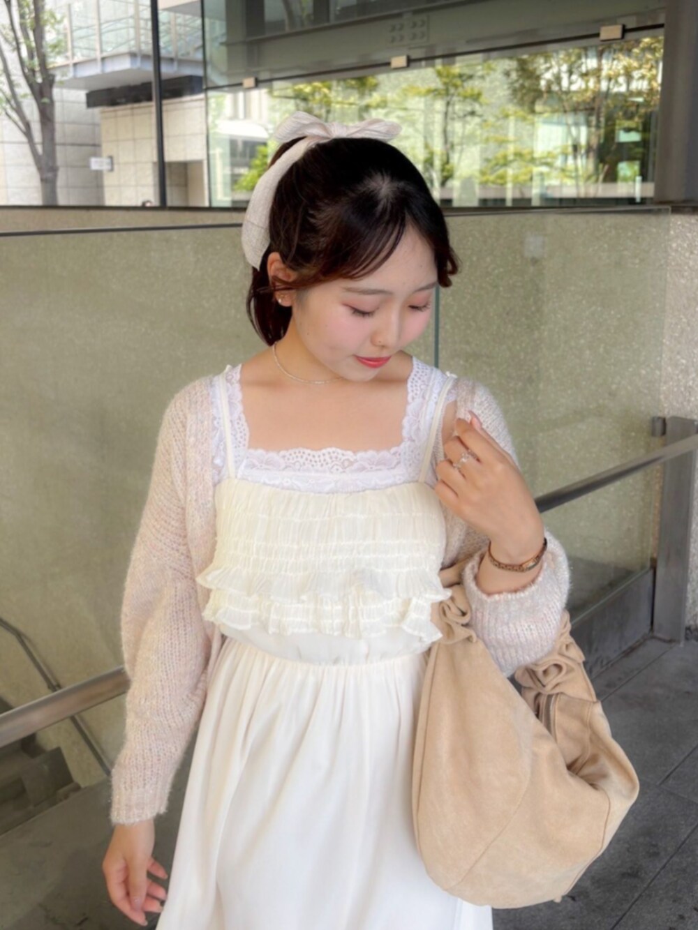 ホワイト系のワンピース、ピンク系のカーディガン/ボレロ、ベージュ系のショルダーバッグを着用したレディースの秋コーディネートの2枚目の写真