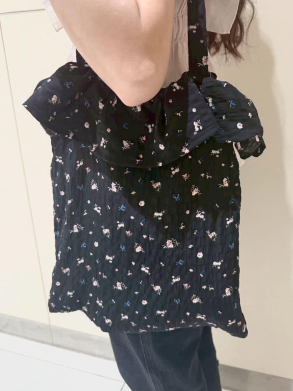 ブラック系のデニムパンツ、ピンク系のシャツ/ブラウス、ブラック系のトートバッグを着用したレディースの夏コーディネートの3枚目の写真