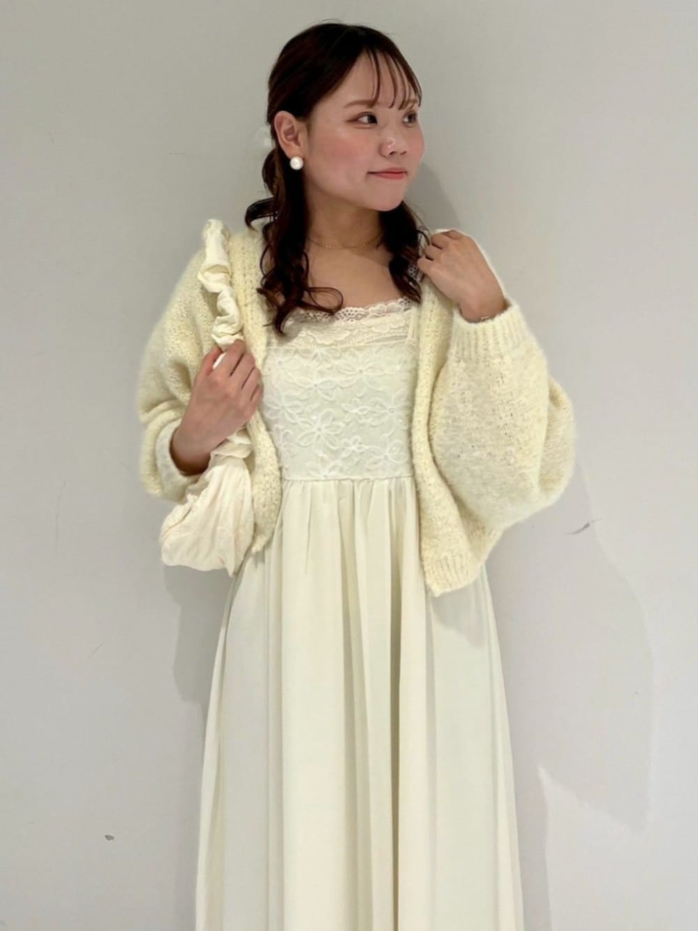 ホワイト系のショルダーバッグ、イエロー系のカーディガン/ボレロ、ホワイト系のワンピースを着用したレディースの春コーディネートの2枚目の写真